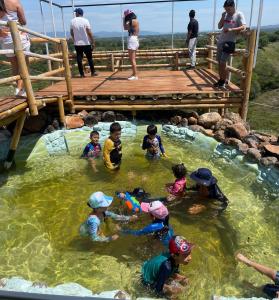un gruppo di bambini che giocano in acqua su un ponte di Venadillo Roca Sólida a Venadillo
