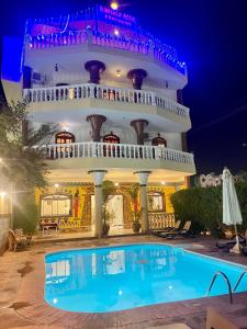 un hôtel avec une piscine en face d'un bâtiment dans l'établissement El Mesala Hotel, à Louxor