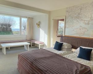 a hotel room with two beds and a large window at West Wittering beach house with direct beach access in West Wittering