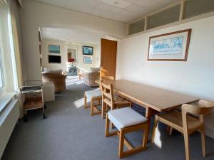 una sala de espera con mesa de madera y sillas en West Wittering beach house with direct beach access en West Wittering