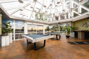 a room with two ping pong tables and a chandelier at Glamping Ackersate in Voorthuizen