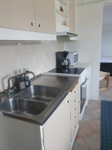 a kitchen with a stainless steel sink and appliances at 50 m till bad i centrala Skärhamn in Skärhamn