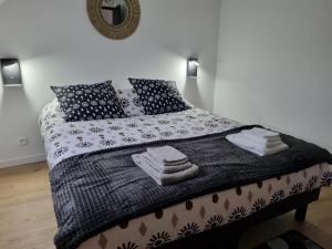 1 dormitorio con 1 cama grande con mantas y almohadas en Gîte Chez Marie T 6 personnes, en La Boussac