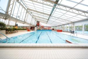 a large swimming pool with a large ceiling at Glamping Ackersate in Voorthuizen +57 photos