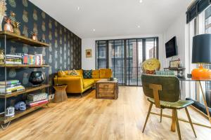 a living room with a yellow couch and a yellow chair at Chic Urban Apartment In Shoreditch 2 bed 2 bath in London