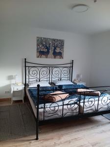 a bedroom with a black bed with a picture on the wall at Apart-Lachmoewe-im-Moewennest-Tossens in Stick