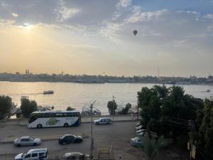 un autobús estacionado en un estacionamiento junto a un cuerpo de agua en El Mesala Hotel, en Luxor