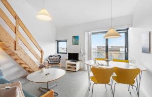 a living room with two tables and yellow chairs at 2 Bedroom Stunning Apartment In Fan in Fanø
