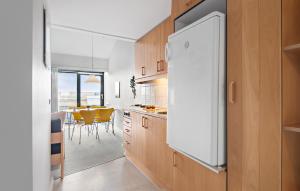 a kitchen with a white refrigerator and a table at 2 Bedroom Stunning Apartment In Fan in Fanø