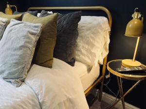 een bed met kussens en een bijzettafel met een lamp bij The Old Farmhouse in Bristol