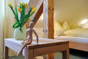 a doll sitting on a table in a bedroom at Pension Schindlau in Scharnstein