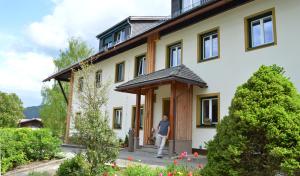 uma pessoa de pé na porta de uma casa em Pension Schindlau em Scharnstein