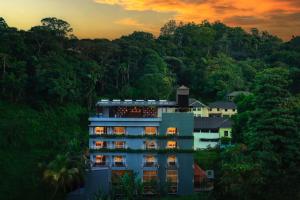 a building in the middle of a hill with trees at Serene Kandy in Kandy