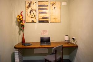 a desk with a laptop and a vase of flowers at Casetta Ponte Milvio in Rome