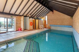 een groot zwembad in een gebouw met een zwembad bij Swallow Cottage at Robin Hill 4 in Bideford