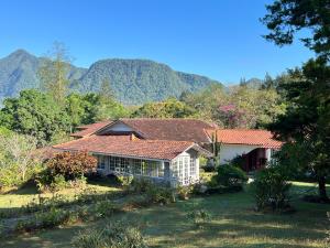 ein Haus auf einem Feld mit Bergen im Hintergrund in der Unterkunft Casa Naturaleza in El Valle de Antón