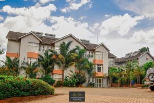 a building with palm trees in front of it at Milimani Resort Kakamega in Kakamega