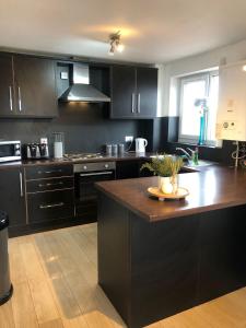a kitchen with black cabinets and a wooden counter top at Walnut Apartments in Brumby