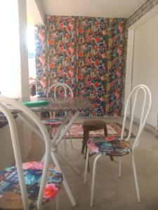 uma sala de jantar com cadeiras, uma mesa e uma cortina em Camping estrela Ubatuba em Ubatuba