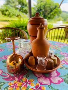 einen Tisch mit einer Vase und anderen Gegenständen darauf in der Unterkunft Chácara Nascimento in Vitória de Santo Antão