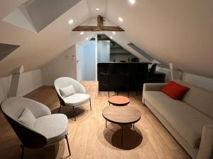 uma sala de estar com um sofá, cadeiras e uma mesa em Hôtel du Château Dinan - Originals Boutique em Dinan
