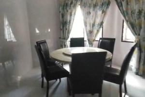 a dining room with a table and chairs and a window at Luxury Bungalow in Senawang in Seremban