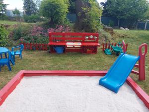 un parco giochi con scivolo blu e panca rossa di U Alchemika 