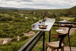 una mesa con una botella de vino y un tazón de comida en Amazing mountain loft in La Cumbre en Los Cocos