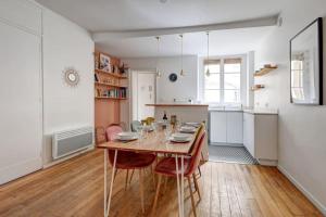 a kitchen and dining room with a table and chairs at Louvre Montorgueuil Historical center 3BR II in Paris