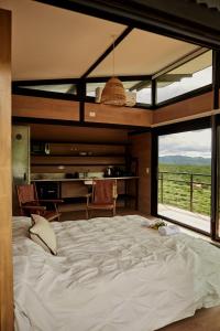 Cama grande en habitación con ventana grande en Amazing mountain loft in La Cumbre en Los Cocos