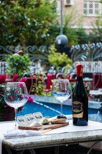 una botella de vino sentada en una mesa con dos copas en Hotel Elysee, en Tirana
