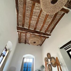 um quarto com um tecto com relógios e uma janela em Loft incroyable en médina em Essaouira