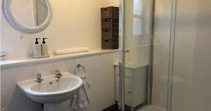 a white bathroom with a sink and a shower at Spacious Modern Apartment in St. Andrews +19 photos