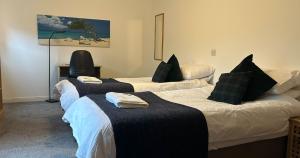 a room with three beds with black pillows at Spacious Modern Apartment in St. Andrews