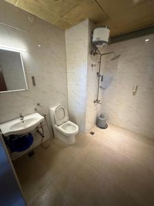 a bathroom with a toilet and a sink and a shower at Gulnaar Inn in Chennai