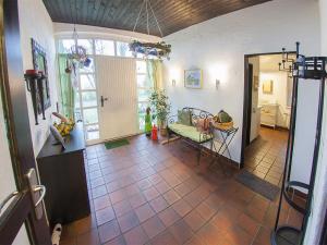 uma sala de estar com piso em azulejo e uma mesa em Landhaus Birkenhof, FeWo Vermittlung Nordsee 