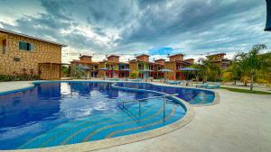 a large swimming pool in front of some houses at Pousada Lençóis Maranhenses in Santo Amaro