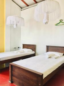 um quarto com 2 camas, um lavatório e um espelho em Railway Hostel em Matara