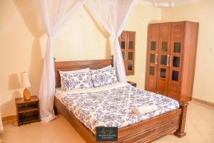 een slaapkamer met een hemelbed bij Milimani Resort Kakamega in Kakamega