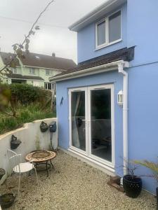 uma casa azul com uma mesa e cadeiras em frente em Kinterbury Annexe em Plymouth