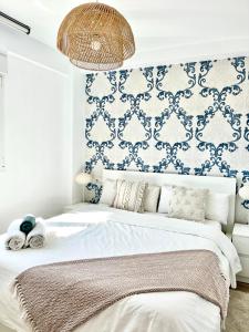 um quarto com uma cama com uma parede azul e branca em Huelin Park Apartment em Málaga