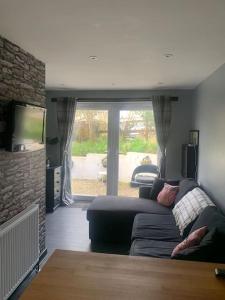 Kinterbury Annexe في بلايموث: غرفة معيشة مع أريكة وتلفزيون