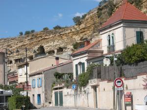 a group of buildings on the side of a mountain at studio au pied des troglodytes, près de la plage in Saint-Chamas