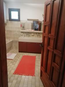 a bathroom with two sinks and a red rug at Apartment Relax in Zrenjanin