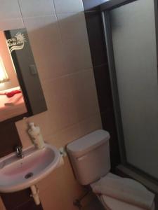 a bathroom with a toilet and a sink at Hostal Costa Azul in Manta