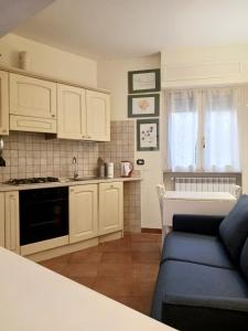 a kitchen with white cabinets and a blue couch at èROMA - AVENTINO Apartment in Rome +3 photos