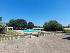 a swimming pool with a fence next to it at Casale del Gufo in Chiaravalle
