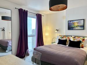 a bedroom with a bed with purple curtains and a window at Central Belfast Apartments Sandford in Belfast