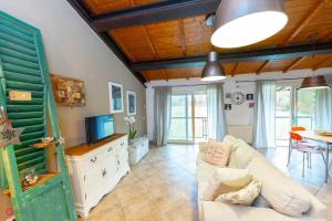 ein Wohnzimmer mit einem weißen Sofa und einem TV in der Unterkunft Casa Fevira Borgo in Borgo San Lorenzo