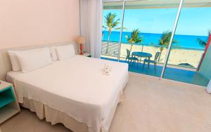 1 dormitorio con cama y vistas a la playa en Hotel Praia Dourada, en Maragogi